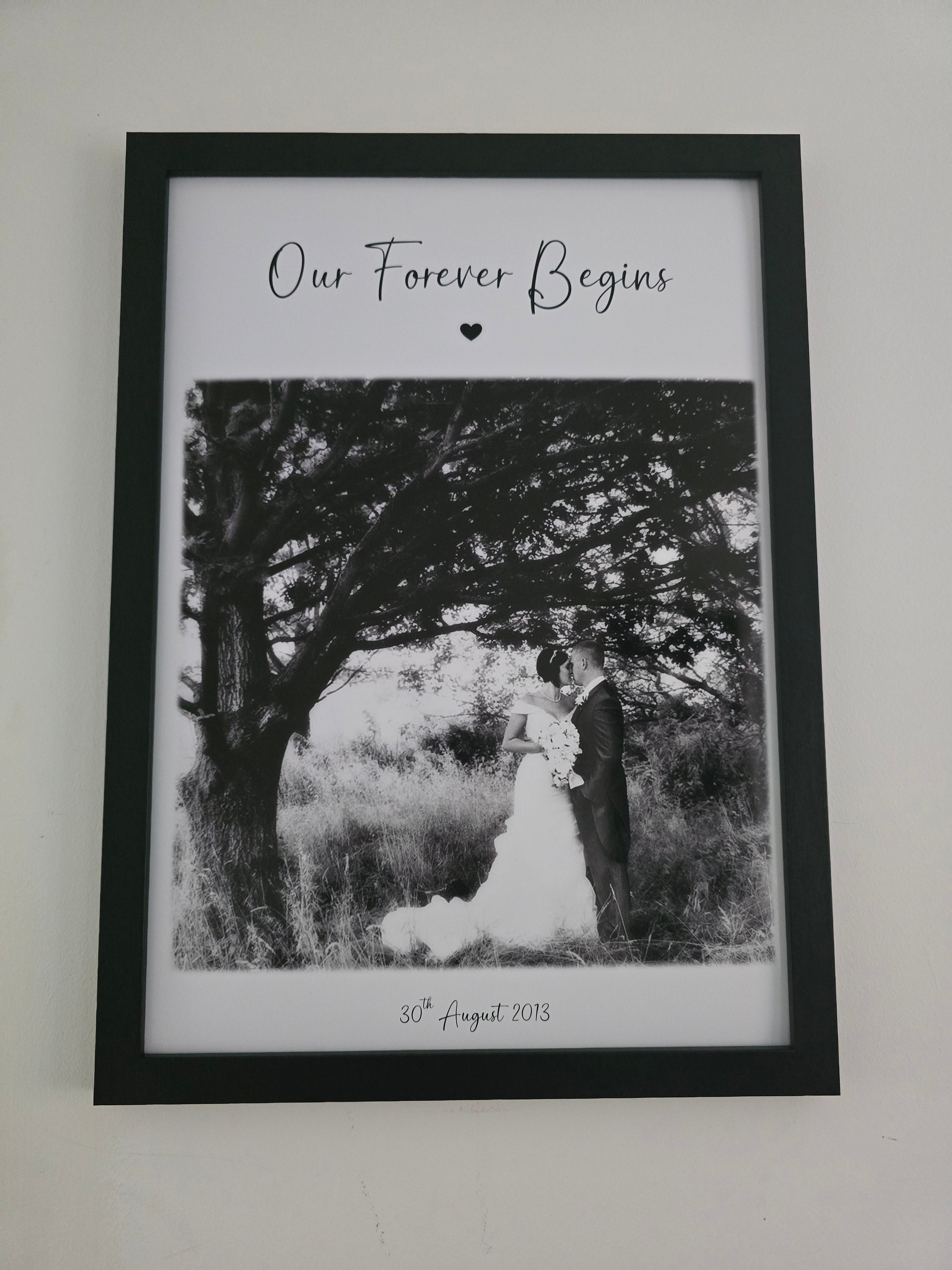 Framed black and white photograph with text on a white wall